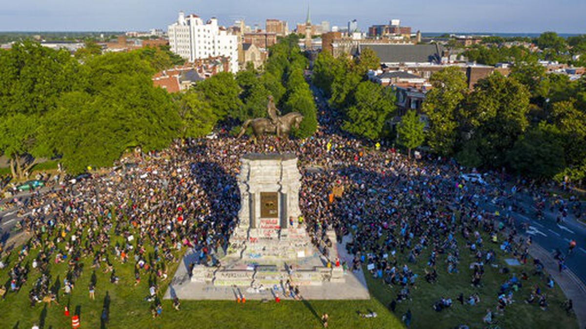In this photo taken with a drone, a large group of protesters gather around the statue of...