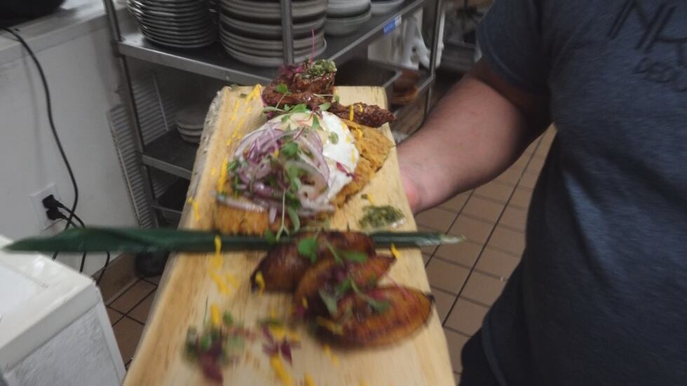 Chef Eddy Moreno shows off a delicious entree with steak, taku taku with an egg on top and...