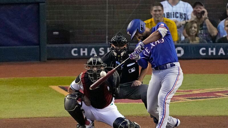 Texas Rangers' Marcus Semien hits an RBI single as Arizona Diamondbacks catcher Gabriel Moreno...