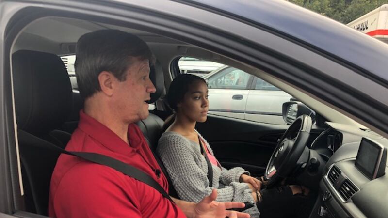 Instructor Jim Stepp gives some quick instructions to student Macy Thompson before her driving...