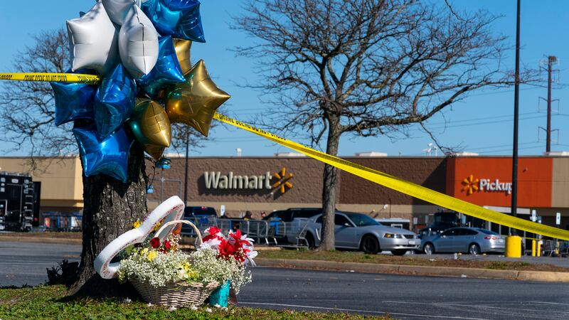 Flowers and balloons have been placed near the scene of a mass shooting at a Walmart,...
