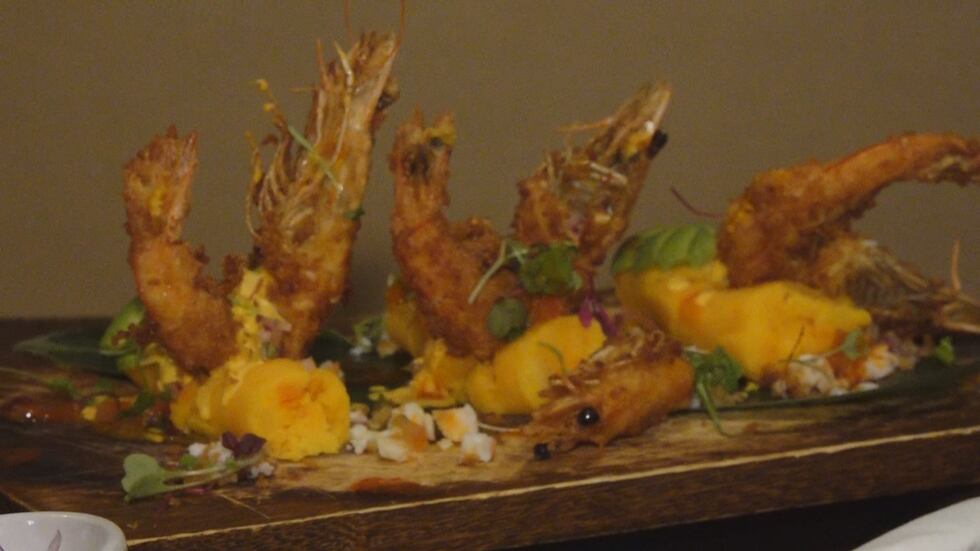 Fried shrimp on a bed of yellow potatoes.
